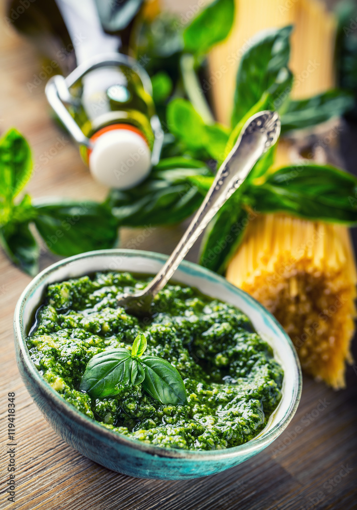 Fresh basil leaves pesto garlic and spaghetti on wooden table. Fresh basil leaves pesto garlic and spaghetti on wooden table.
