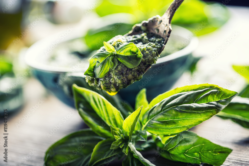 Fototapeta premium Fresh basil leaves pesto on wooden table.