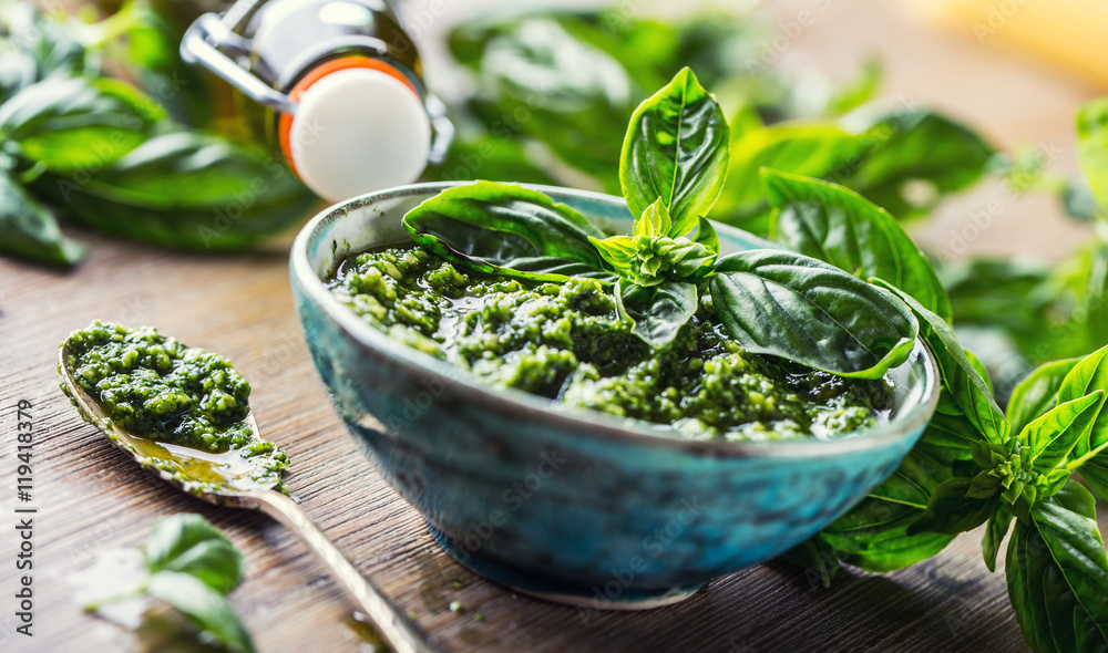 Fresh basil leaves pesto on wooden table. Fresh basil leaves pesto on wooden table.