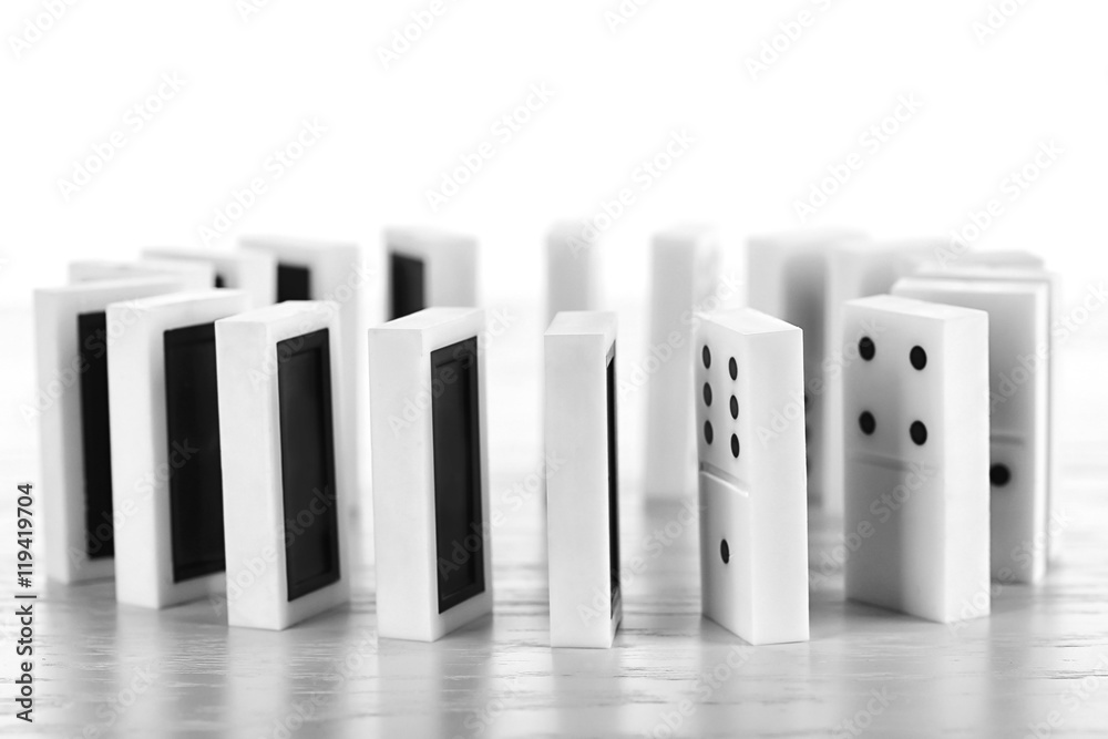 Circle of dominoes standing on light wooden background Circle of dominoes standing on light wooden background