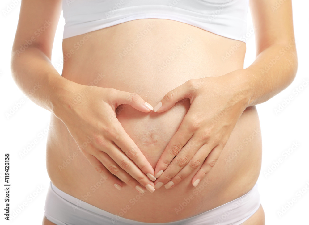 Pregnant woman holding hands on belly, closeup