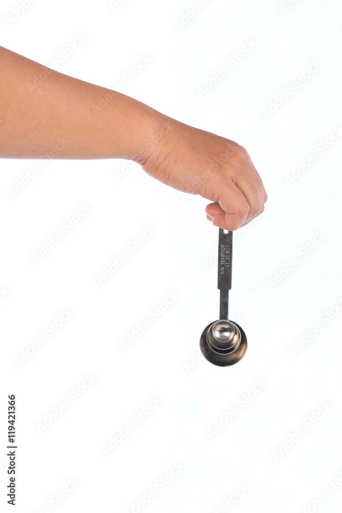 hand hold steel measuring spoons on white background,selective focus hand hold steel measuring spoons on white background,selective focus