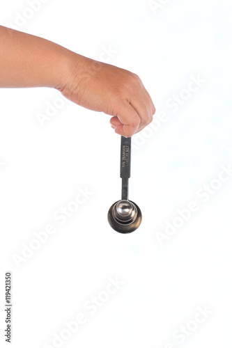 hand hold steel measuring spoons on white background,selective focus