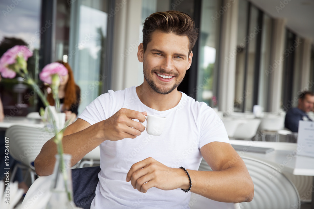 Portrait of young handsome man drinking coffee