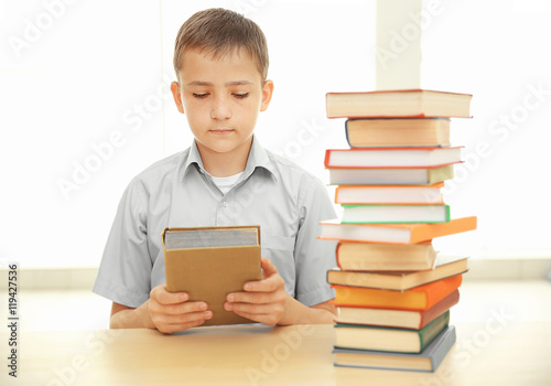 Boy with many books at school