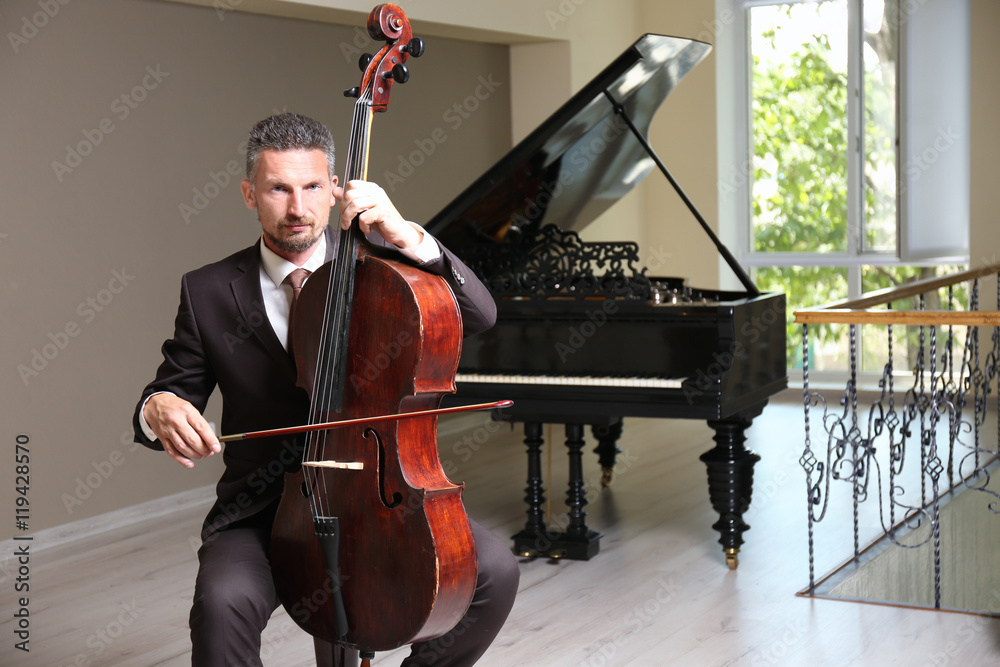 Fototapeta premium Man playing cello in room