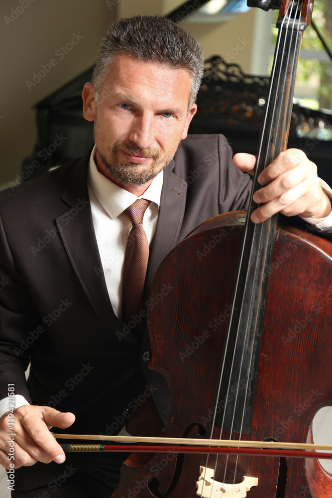 Man playing cello in room Man playing cello in room