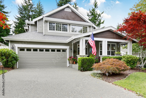 Nice curb appeal of grey house with covered porch and garage photo
