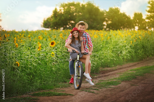 Fototapeta Naklejka Na Ścianę i Meble -  Young couple on bicycle in field