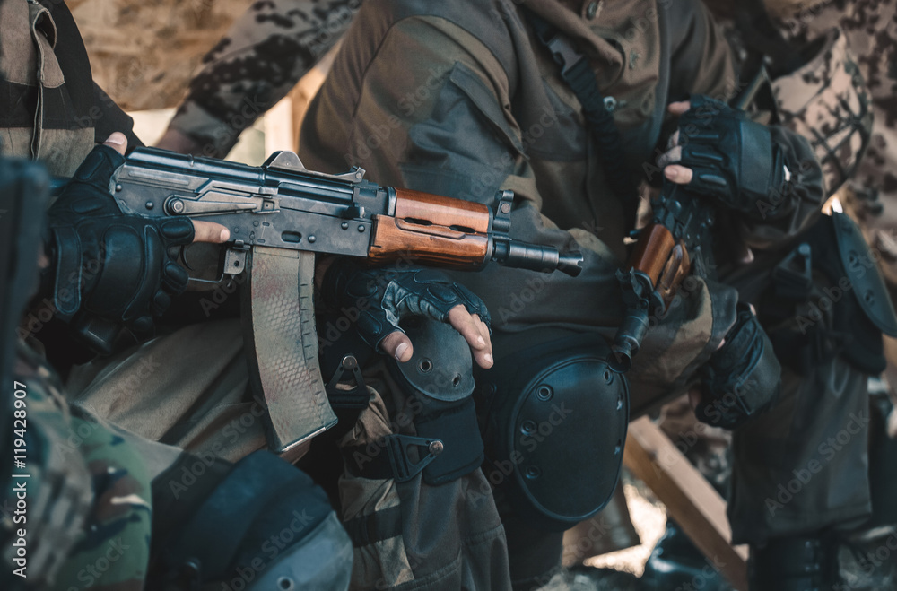 Two soldiers in camouflage and gloves keep the hands in the machines. Two soldiers in camouflage and gloves keep the hands in the machines.