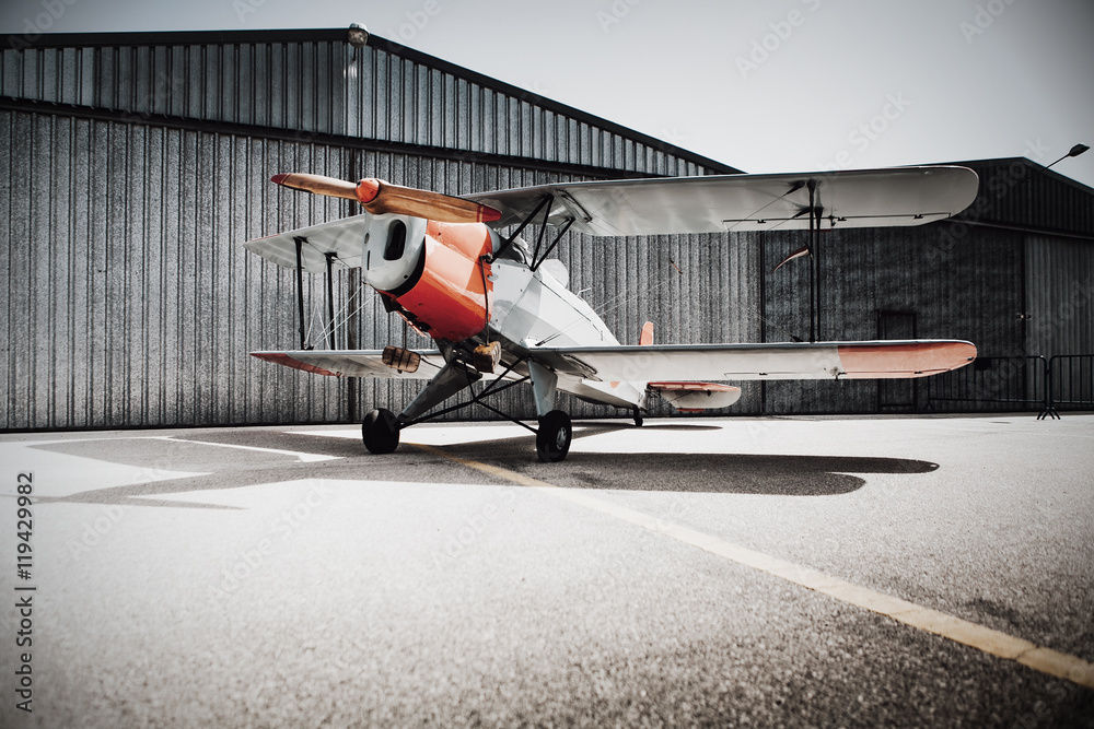 Vintage old plane in front of the hangar. Copyspace on the ground ...
