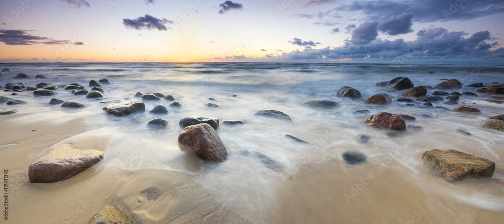 Fototapeta premium Zachód słońca nad bałtycką plażą,głazy piastowskie na wyspie Wolin 