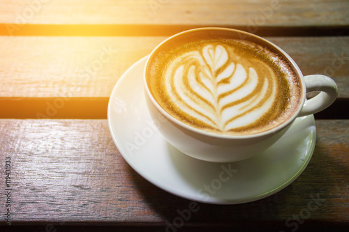 A Latte Coffee cup art on wooden desk.