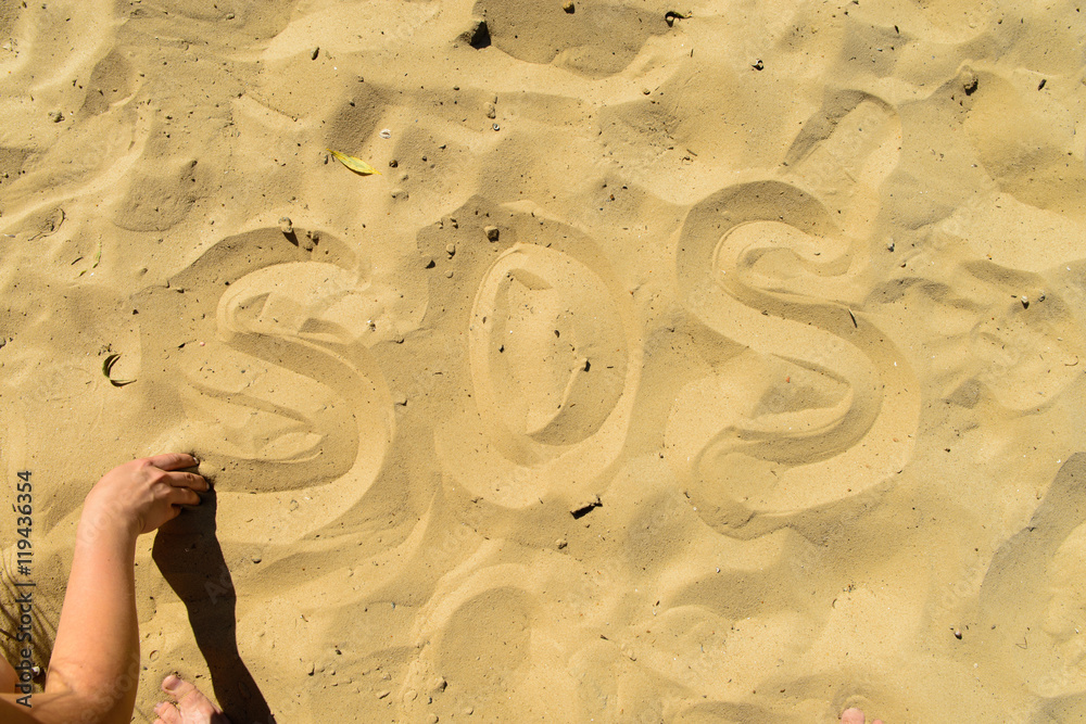 Obraz premium inscription SOS in the sand on the beach