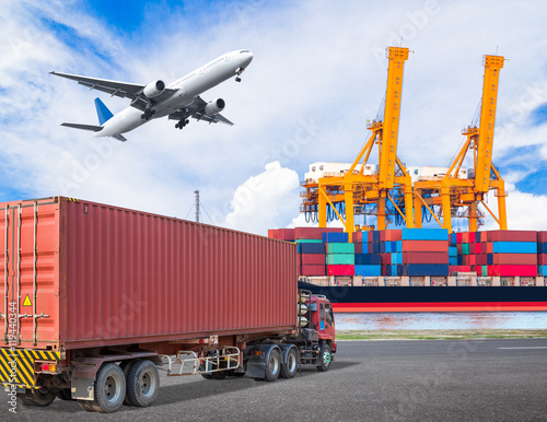 Truck transport container and cago plane flying above ship port photo