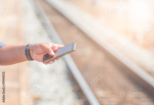 His right hand was holding a smart phone platform railway. Photo light The tone and white balance. © 994yellow