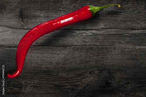 Red chili pepper isolated on wooden background