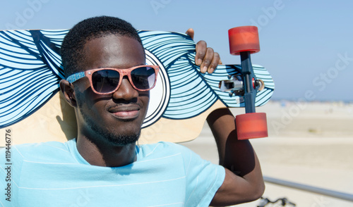 Young man outdoors with his skateboard photo