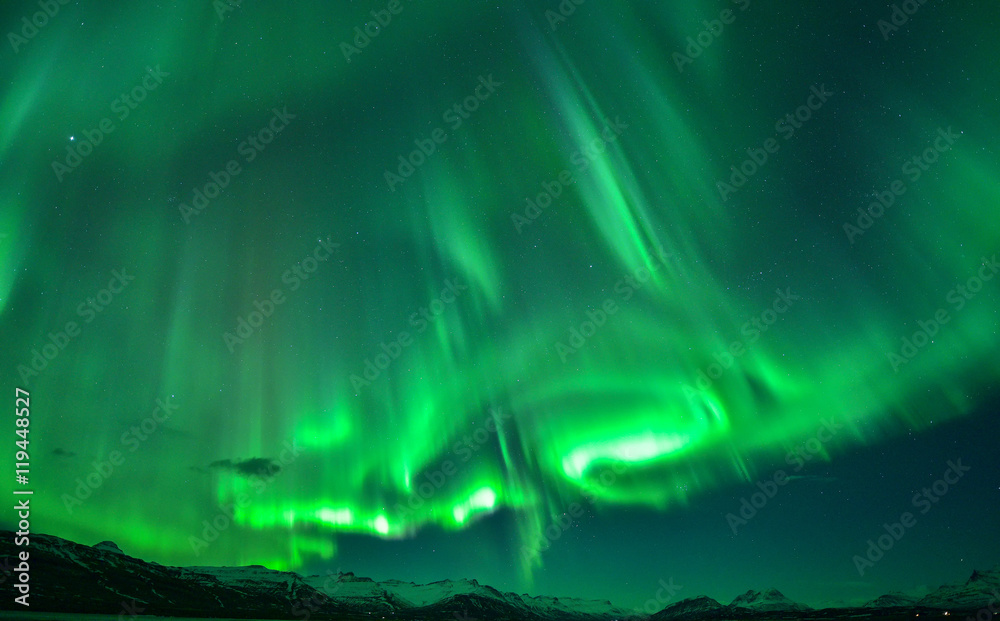 Spectacular auroral at night display over mountain,Iceland