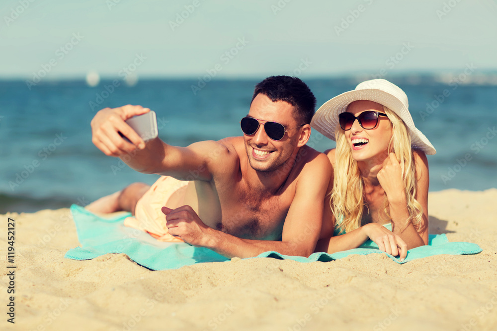 Fototapeta premium happy couple in swimwear walking on summer beach