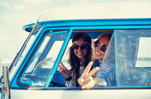 smiling young hippie women driving minivan car photo