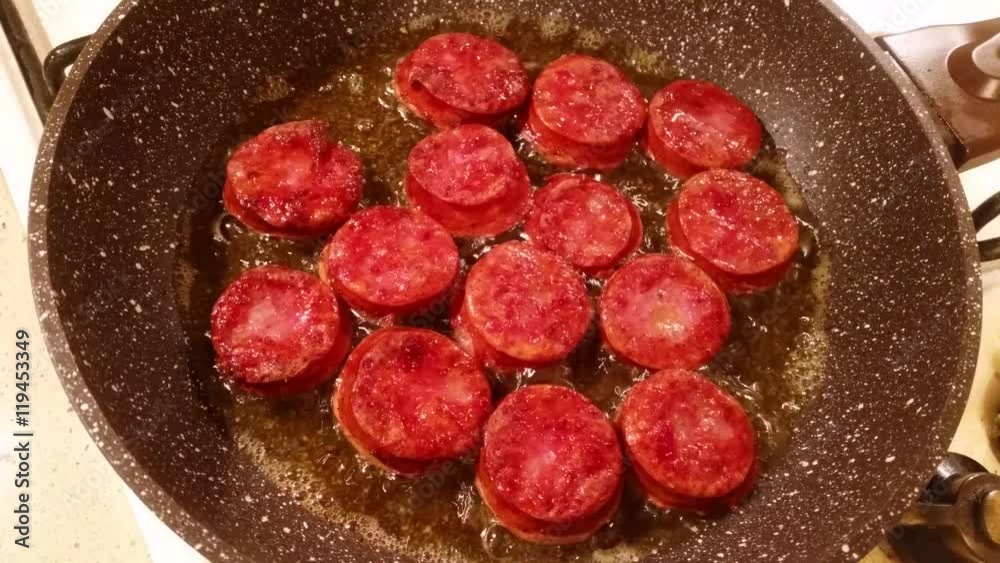 Fragrant smoked sausage with spices fried in a pan Fragrant smoked sausage with spices fried in a pan