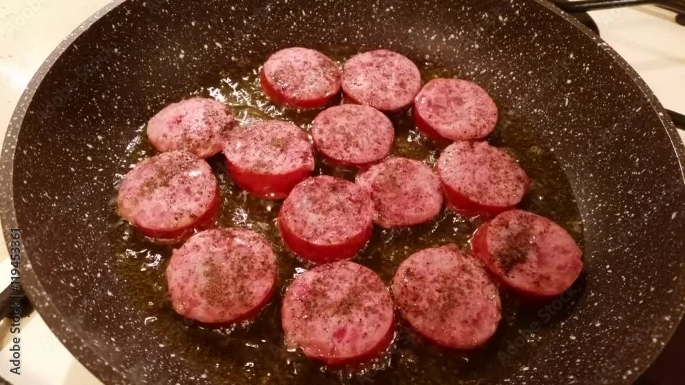 Fragrant smoked sausage with spices fried in a pan Fragrant smoked sausage with spices fried in a pan