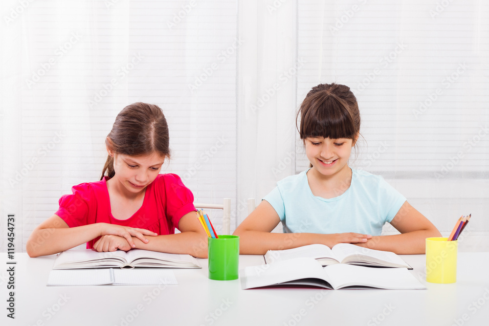 Cute little girls are doing their homework.

