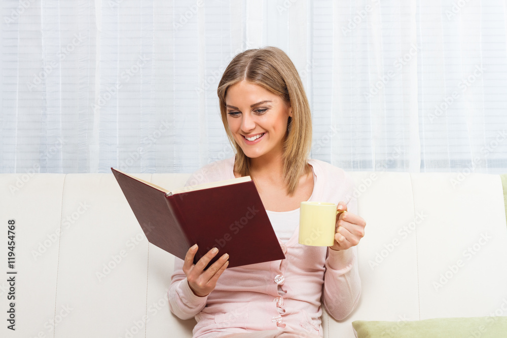 Young beautiful woman is reading a book,drinking tea or coffee and enjoys in her free time at home.
Young beautiful woman is reading a book,drinking tea or coffee and enjoys in her free time at home.
