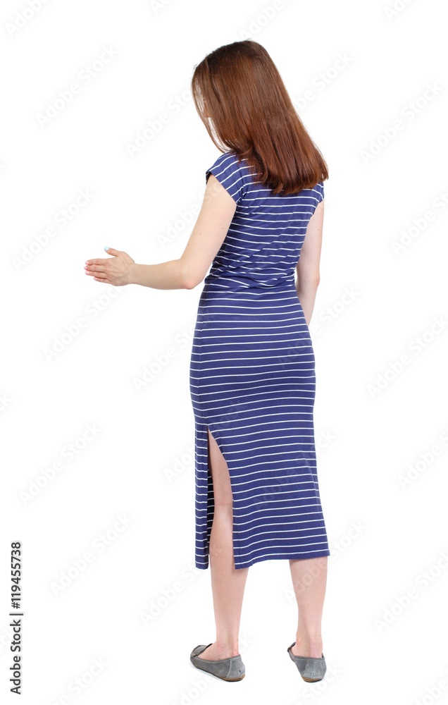 back view of woman shake hands. brunette in a blue striped dress holds out his hand for a handshake. back view of woman shake hands. brunette in a blue striped dress holds out his hand for a handshake.