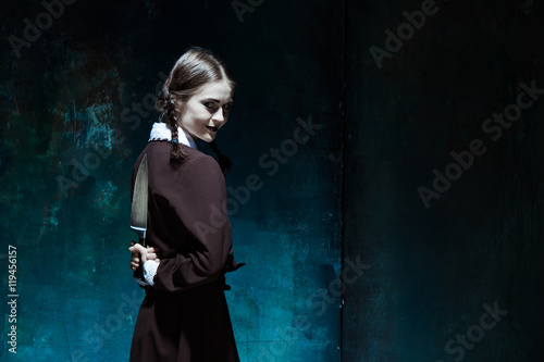 Fotografie Portrait of a young girl in school uniform as killer woman