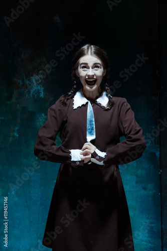 Portrait of a young girl in school uniform as killer woman
