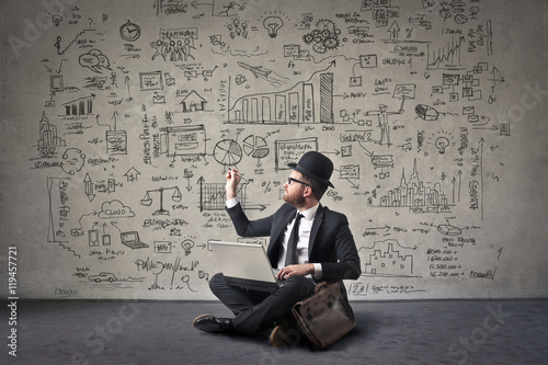 Businessman drawing schemes on a wall