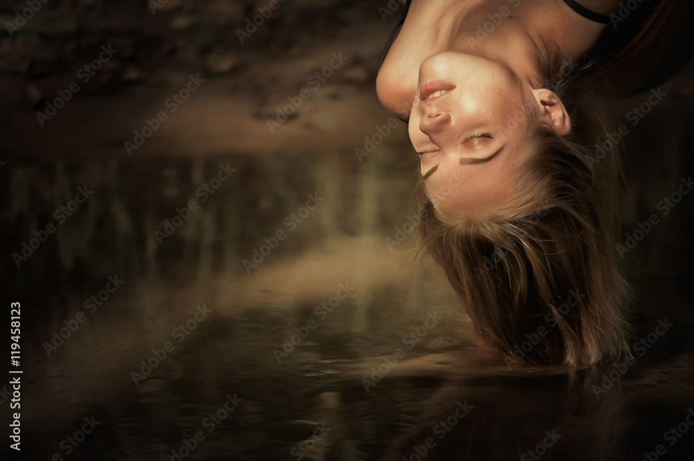 girl lying in a hammock above the river, and her hair in water girl lying in a hammock above the river, and her hair in water