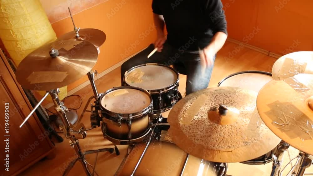 A drummer performing on his Drumset.
