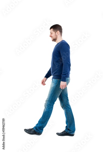 Back view of going handsome man. walking young guy . bearded man in blue pullover thoughtfully misses.