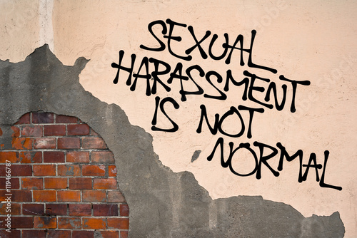 Sexual Harassment Is Not Normal - Handwritten graffiti sprayed on wall, anarchist aesthetics - appeal to resist and fight against sexually offensive behavior and verbal or physical assault photo