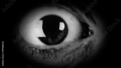 The big eye of a woman, looking in camera, scared. Film-noir style. Detail macro shot.
 photo