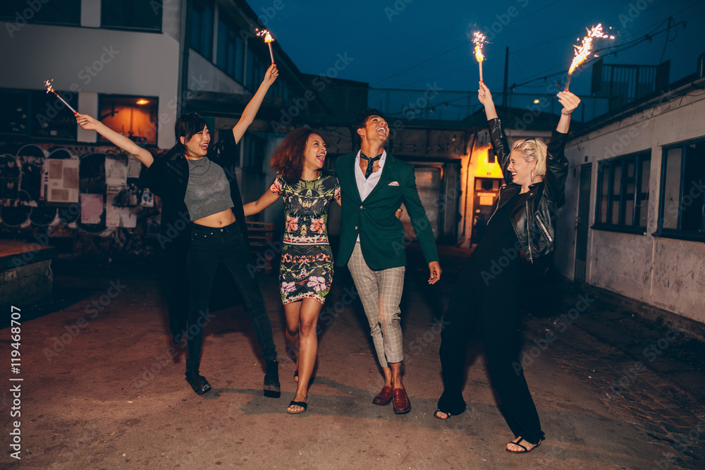 Fototapeta premium Group of friends enjoying with sparklers on road