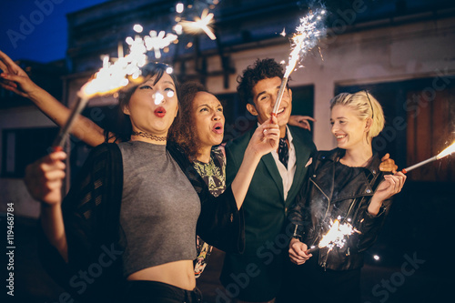 Stampa su tela Young people enjoying new years eve with fireworks