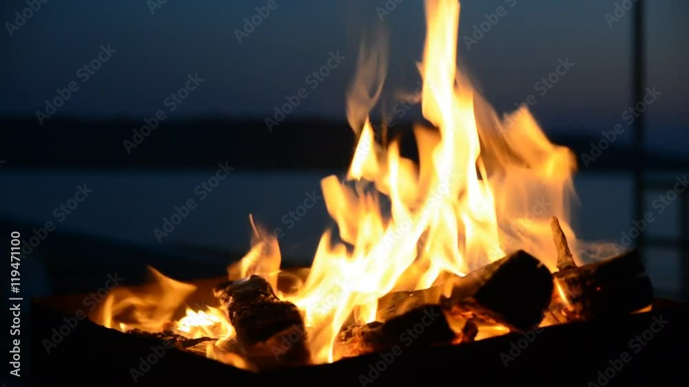 The firewood burning in a brazier closeup in the night. The firewood burning in a brazier closeup in the night.