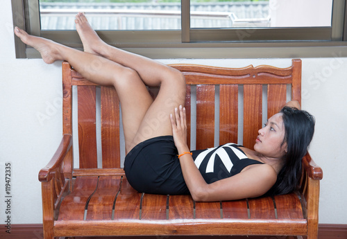 Attractive woman in minidress resting on a bench