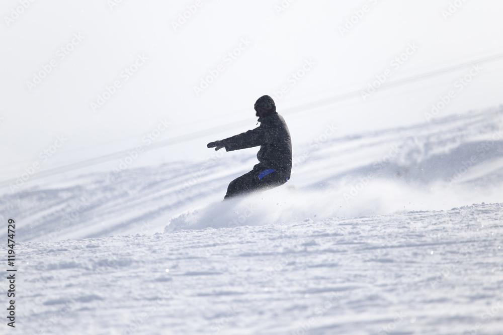 Snowboarding man at flattened piste - slope