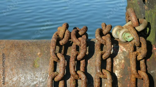 Rusty iron chains beside a lake. photo