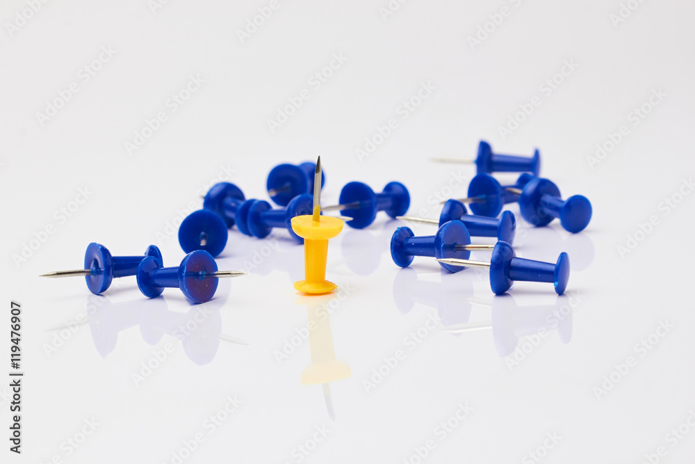 Blue and yellow thumbtacks on a white background./Blue and yellow thumbtacks on a white background.