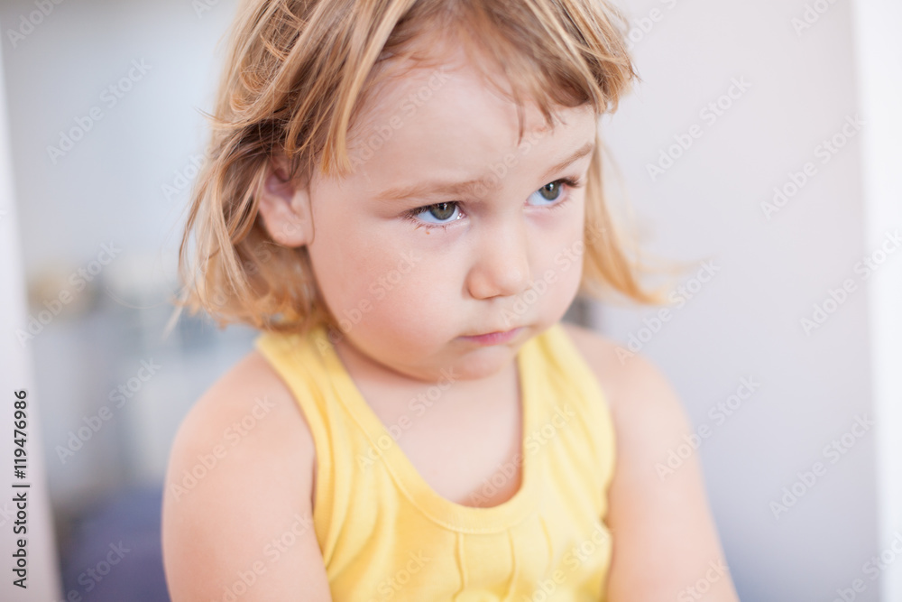portrait of blonde two years old child with yellow shirt looking with sad face
portrait of blonde two years old child with yellow shirt looking with sad face