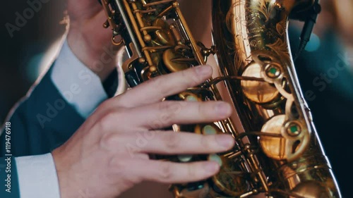 Saxophonist in dinner jacket play on golden saxophone. Live performance. Jazz music.