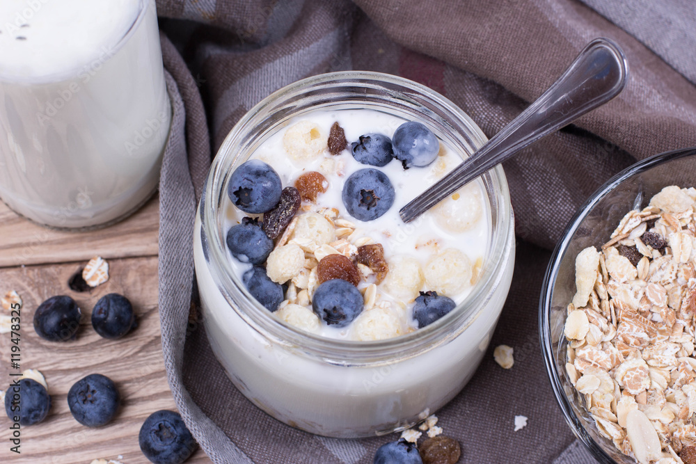 Yogurt with blueberry and cereal of glass in a jar on a wooden t Yogurt with blueberry and cereal of glass in a jar on a wooden t