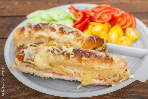 Tasty sandwich with ham, melted cheese and vegetables
