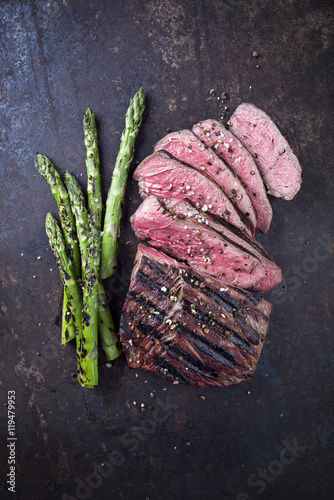 Gegrilltes Hüftsteak mit grünen Spargel auf altem Blech photo